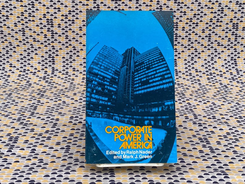 May include: A book cover with a blue background and a photo of a city skyline. The title is "Corporate Power in America" and the authors are Ralph Nader and Mark J. Green.