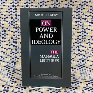 Op de afbeelding: Een grijs boek met de titel "On Power and Ideology: The Managua Lectures" van Noam Chomsky. De omslag van het boek heeft witte tekst op een grijze achtergrond.
