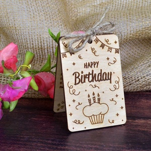 Finished engraved wood card with a cupcake design and "Happy Birthday" text. Hand-assembled wooden greeting card tied with twine, perfect as a bday gift for a friend. Compatible with CO2 laser machines.