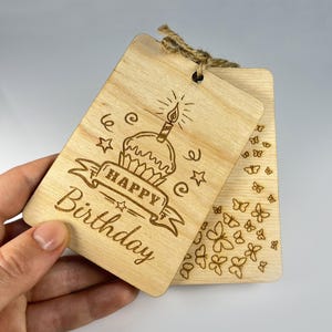 Close-up of a laser engraved wooden card showing intricate butterfly patterns and birthday text. Compact greeting card design (2.8x4") with professional vector engraving. Hand-drawn elements by GoodwoodUAShop.