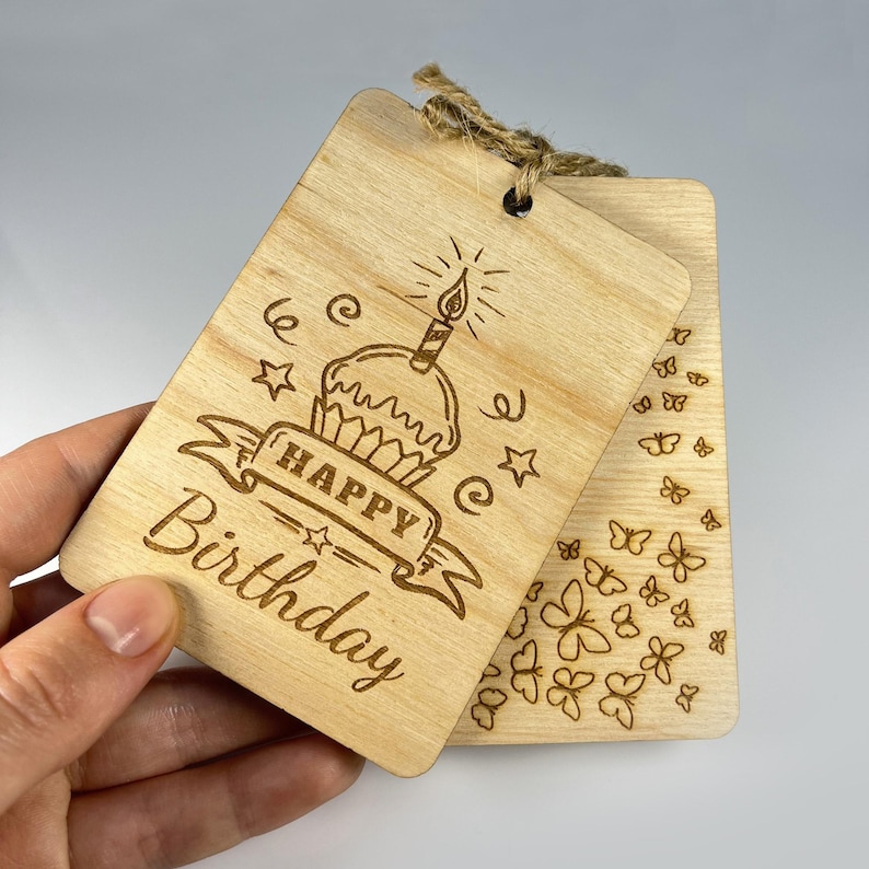 Close-up of a laser engraved wooden card showing intricate butterfly patterns and birthday text. Compact greeting card design (2.8x4") with professional vector engraving. Hand-drawn elements by GoodwoodUAShop.