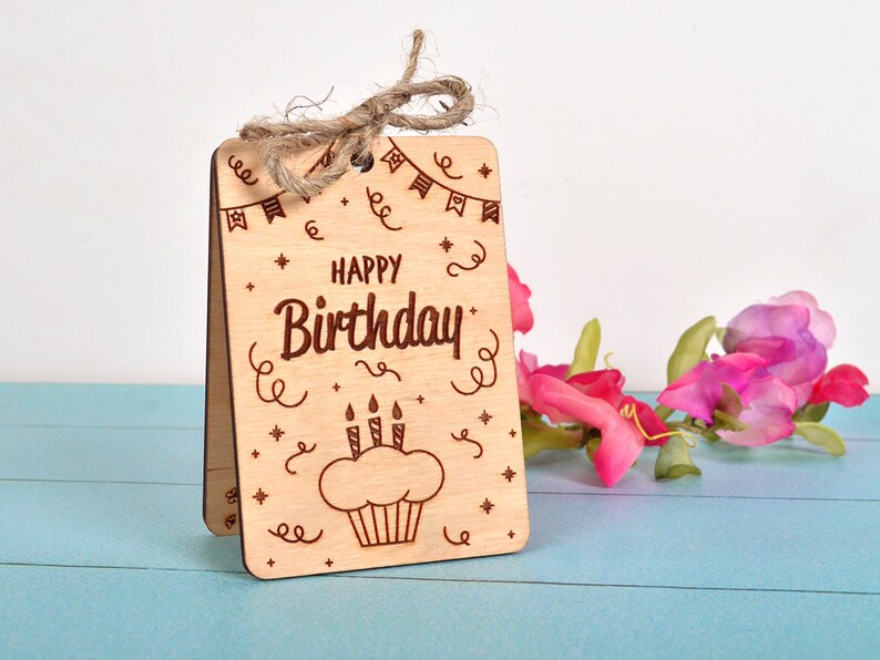 Finished engraved wood card with a cupcake design and twine bow. Tested on laser cutting machines with 3mm wood.