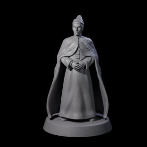May include: A gray statue of a person in formal attire, featuring a long robe and cape. The figure has a hat and clasped hands, standing on a circular base. The statue is set against a black background.