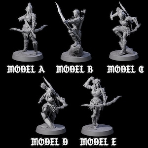 Può includere: Cinque figurine grigie in miniatura di arcieri in varie pose d'azione, ognuno con arco e freccia. Le figurine sono etichettate da "MODELLO A" a "MODELLO E" in un carattere gotico. Gli arcieri indossano armature e abiti dettagliati.