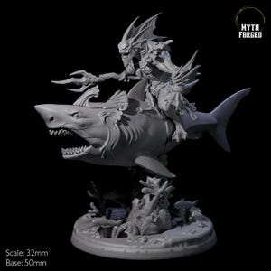 Puede incluir: Una miniatura impresa en 3D de color gris de una criatura montando un tiburón. La criatura tiene aletas y un tridente. El tiburón está sobre una base con coral. La miniatura tiene una escala de 32 mm y la base mide 50 mm. MYTH FORGED está impreso en la imagen.