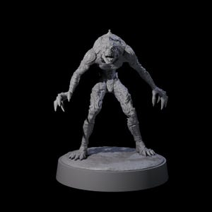 Può includere: Una statuetta di mostro grigio strutturato con artigli e denti affilati, in piedi su una base circolare. La creatura ha un aspetto ruvido e squamoso ed è in posa con le braccia tese. Lo sfondo è nero.