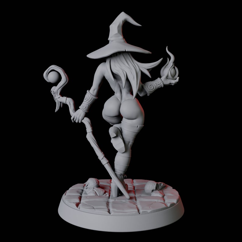 May include: A gray painted miniature figurine of a witch wearing a pointed hat and holding a staff and a flaming orb. The witch is standing on a circular base with a stone-like texture.
