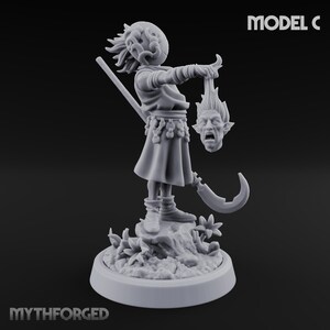 May include: A gray miniature figure of a character holding a severed head. The figure is dressed in a tunic and boots, with a scythe at its side. The base is decorated with foliage, and the text "MODEL C" is visible.