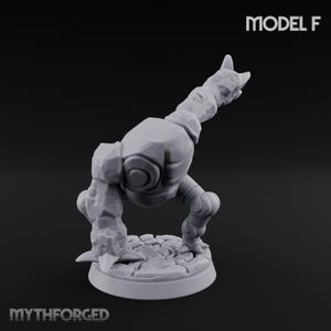 May include: A light grey, unpainted miniature figure of a rock creature standing on a circular stone-textured base. The figure has a bulky, segmented torso, a long neck, and clawed limbs. The text MODEL F and MYTHFORGED are visible.
