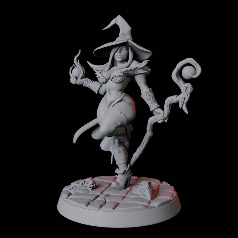 May include: A gray 3D printed miniature of a female witch wearing a pointed hat and holding a staff with a sphere on top. She is standing on a circular base with a textured surface.
