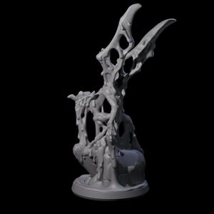 May include: A grey, 3D-printed sculpture of a creature with a skeletal, winged upper body and a blob-like lower body. The sculpture has a textured, melted appearance and sits on a round base against a black background.