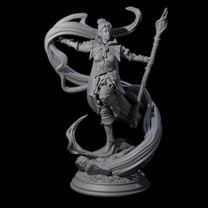 Puede incluir: Una figura gris de una figura femenina en una pose dinámica, sosteniendo un bastón y rodeada de tela fluida. La figura está vestida con un atuendo de fantasía detallado, de pie sobre una base rocosa con un pedestal circular. El fondo es negro.