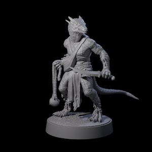 May include: A gray, three-dimensional figurine of a humanoid lizard creature. The figure is posed with a weapon in one hand and a mace-like object in the other. The creature is wearing a sash and bandages. The figurine is on a circular base.