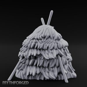 May include: A grey miniature hay bale with a layered, textured design. Two vertical sticks protrude from the top, and two angled sticks support the structure. The base features the text "MYTHFORGED".