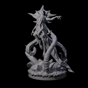 Puede incluir: Escultura gris de una criatura con cabeza en forma de estrella, múltiples tentáculos y cuerpo humanoide. La escultura está sobre una base rocosa con fondo oscuro. Los brazos de la criatura están extendidos.