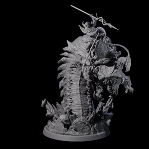 May include: A detailed grey miniature sculpture of a warrior riding a monstrous creature. The warrior is armed with a spear and shield. The creature has a segmented body and a menacing face, set on a round base.