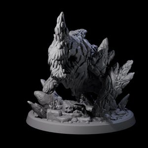 May include: A gray, 3D-printed monster figurine with a rocky, textured appearance. The creature has sharp teeth, spiky protrusions, and is posed on a base with rocks and a skull. The background is black.