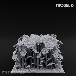 May include: A grayscale 3D-printed model of a cluster of daisies. The flowers have multiple petals and are surrounded by stems, leaves, and small mushrooms. The model is labeled "MODEL D" in the upper right corner and has the "MYTHFORGED" logo at the bottom.