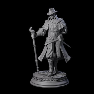 May include: A detailed gray figurine of a character in a hat and long coat, holding a staff. The figure is standing on a circular base with intricate detailing. The character has a sword at their side.