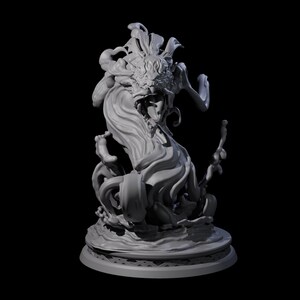 Op de afbeelding: Een gedetailleerde, grijze sculptuur van een mythisch wezen met een drakenkop en vloeiende, golfachtige vormen. De sculptuur is gemonteerd op een cirkelvormige basis met een decoratieve rand, tegen een zwarte achtergrond.