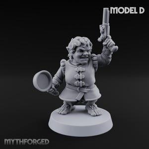 May include: A gray miniature figurine of a fantasy character, holding a pistol in one hand and a magnifying glass in the other. The figure is wearing a tunic and standing on a round base. The text "MODEL D" is visible.