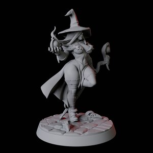 May include: A gray painted miniature figurine of a female witch wearing a pointed hat and holding a staff with a glowing orb at the top. The witch is standing on a gray base with a cobblestone design.