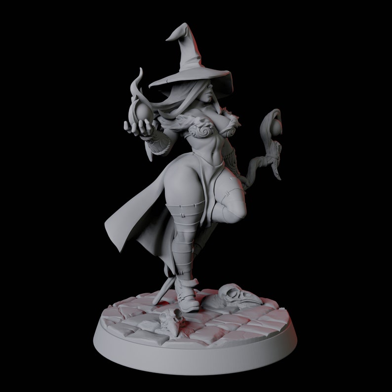 May include: A gray painted miniature figurine of a female witch wearing a pointed hat and holding a staff with a glowing orb at the top. The witch is standing on a gray base with a cobblestone design.