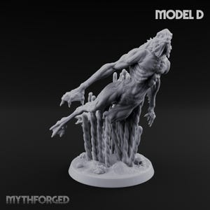 Puede incluir: Figura gris detallada de una criatura humanoide musculosa con manos y pies con garras, posando en el aire. La figura está montada sobre una base con soportes verticales texturizados. El texto "MODEL D" es visible.