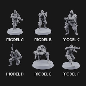 Könnte beinhalten: Sechs graue Miniaturfiguren von Soldaten in Kampfposen, jeweils auf einem kreisförmigen Sockel. Die Modelle sind mit A bis F beschriftet. Die Soldaten tragen taktische Ausrüstung und halten Gewehre.