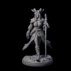 Könnte beinhalten: Graue Fantasy-Figur einer weiblichen Figur mit Hörnern, Stab und detaillierter Kleidung. Die Figur steht auf einem strukturierten Sockel, vor dunklem Hintergrund. Wahrscheinlich für Tabletop-Spiele oder als Dekoration gedacht.
