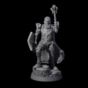 Puede incluir: Figura gris de un caballero medieval, sosteniendo una maza y un escudo. El caballero está vestido con una armadura detallada y se encuentra sobre una base rocosa. La figura tiene una larga barba y posa heroicamente, con una capa.