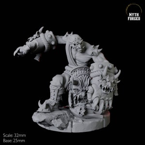 Puede incluir: Figura en miniatura gris detallada de una criatura demoníaca con cuernos en una pose dinámica. La figura tiene una expresión amenazante y sostiene un escudo con múltiples caras de demonios. La base es de 25 mm y la figura mide 32 mm.