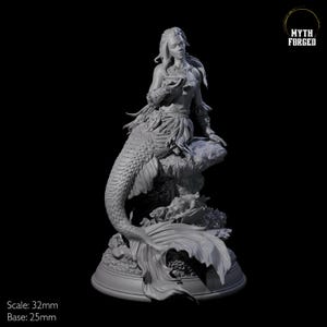 May include: A gray resin figurine of a mermaid sitting on a rock with a cup in her hand. The mermaid has long hair and a tail with scales. The base of the figurine is decorated with coral and seaweed. The figurine is 32 mm in scale and the base is 25 mm.