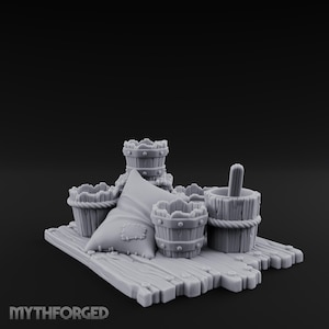 May include: A miniature diorama featuring several wooden buckets, a pillow, and a wooden spoon. The items are arranged on a wooden platform. The scene is rendered in a grayscale color palette.