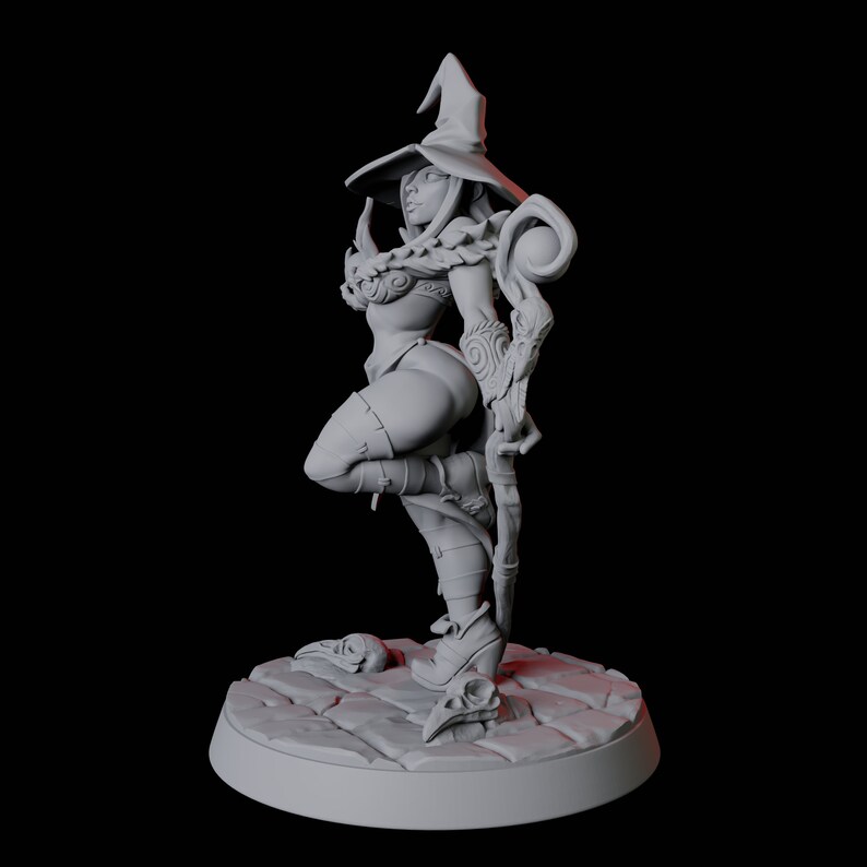 May include: A gray painted miniature figurine of a female witch wearing a pointed hat and holding a staff. The witch is standing on a circular base with a stone-like texture.