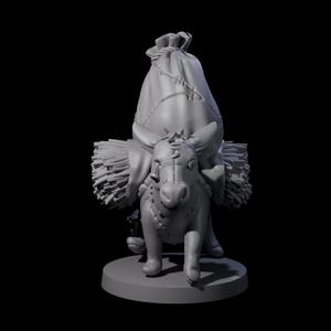 May include: A gray figurine of a donkey carrying a large sack and bundles of hay. The donkey has stitched details and a whimsical design, standing on a round base. The overall theme suggests a fantasy or miniature figure.