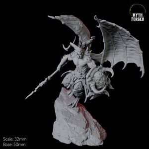 May include: A detailed grey miniature of a demonic figure with large wings, horns, and a spear, standing on a rocky base. The figure is holding a shield with a grotesque face. The text "Myth Forged" is in the upper right corner. Scale: 32mm, Base: 50mm.