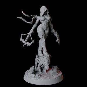 May include: A gray figurine of a female warrior in a hooded cloak, holding a crossbow and a blade. The figure is standing on a detailed base with a monster head and rubble. The statue is a detailed representation of a fantasy character.