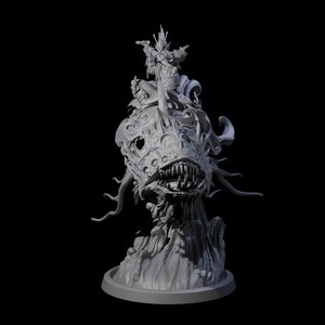 May include: A detailed, gray 3D-printed sculpture of a monstrous creature with sharp teeth and tentacles. A figure sits atop the creature's head, adding to the fantastical design. The sculpture is set against a black background.