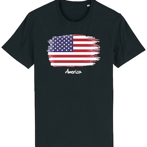 May include: A black t-shirt featuring a watercolour-style American flag design with the word "America" printed below it.