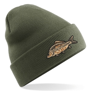 May include: A green knitted beanie with a brown embroidered carp fish design.