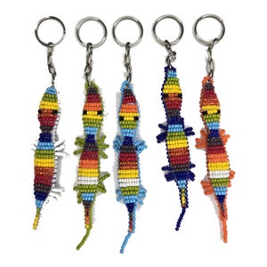 May include: Five beaded lizard keychains in various colors, including red, yellow, blue, and green. Each lizard has a silver keyring attached. The keychains are handmade and feature intricate beadwork.