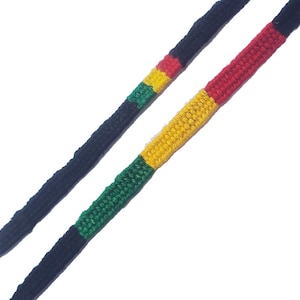 May include: Black shoelaces with a green, yellow, and red stripe pattern.