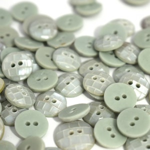 Peut inclure: Un ensemble de boutons vert clair avec une finition texturée et irisée. Certains boutons ont deux trous, tandis que d'autres en ont quatre.