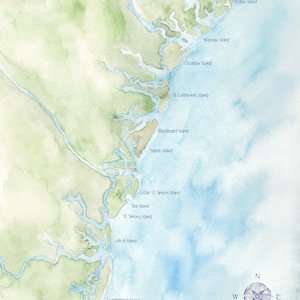 May include: Watercolor map of the Georgia coast, featuring islands like Tybee, Wassaw, and Cumberland. The artwork uses shades of blue and green to depict the ocean and land, with a compass rose in the lower right corner.