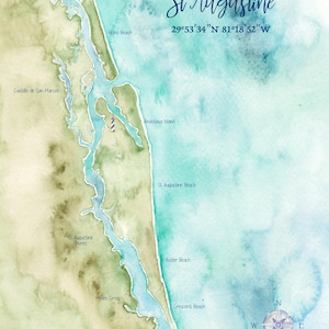 May include: A watercolor map of St. Augustine featuring shades of green and blue. It displays the coastline, landmarks like Castillo de San Marcos and Anastasia Island, and coordinates 29°53'34"N 81°18'52"W. A compass rose is in the corner.