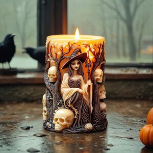 May include: A candle with a witch figure and skulls sculpted into the wax. The witch is wearing a black dress and a pointed hat. The candle is lit and the flame is casting a warm glow.