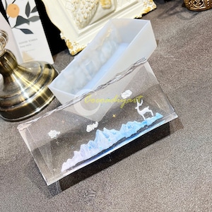 May include: A clear resin tray with a mountain and deer design. The tray is made in a clear silicone mould. The mould is also shown in the image.