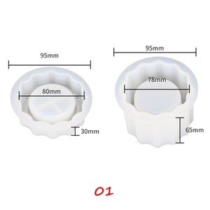 May include: Two white silicone molds for making candles. The larger mold is 95mm wide, 65mm tall, and has a 78mm diameter opening. The smaller mold is 95mm wide, 30mm tall, and has an 80mm diameter opening.