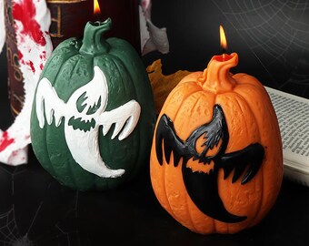 Puede incluir: Dos velas con forma de calabaza con diseños de fantasmas. Una vela es verde con un fantasma blanco, y la otra es naranja con un fantasma negro. Ambas velas tienen llamas encendidas, perfectas para Halloween.